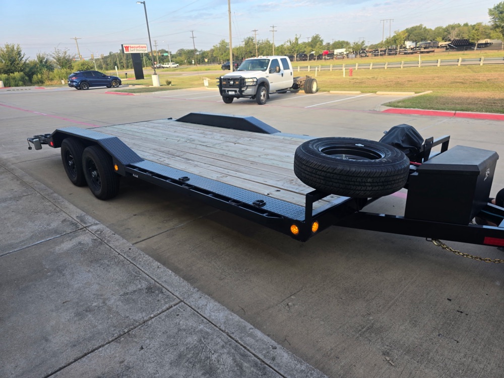 Front three-quarter view of the Silverback super-wide car hauler showing the full wood deck and mounted spare tire