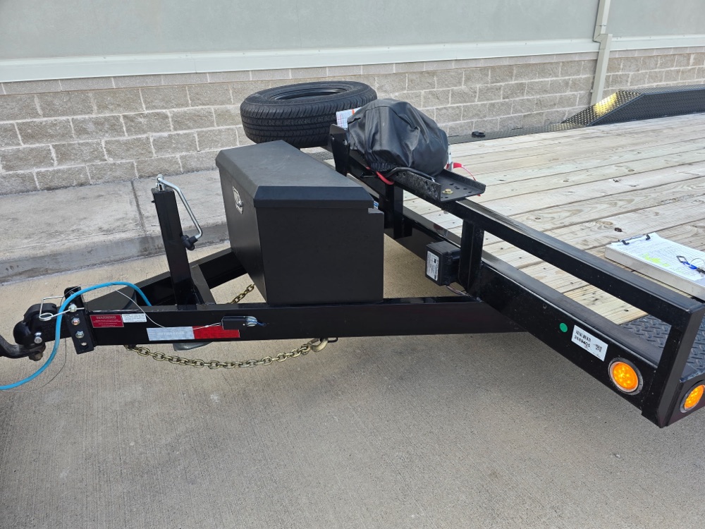 Close-up of the super-wide car hauler coupler, jack, safety chains, and front toolbox